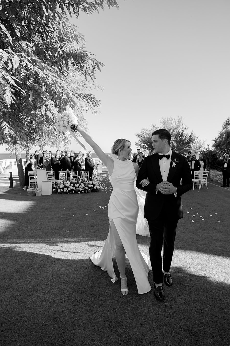 Bride and groom exit the ceremony at their black tie wedding at Xalet del Nin